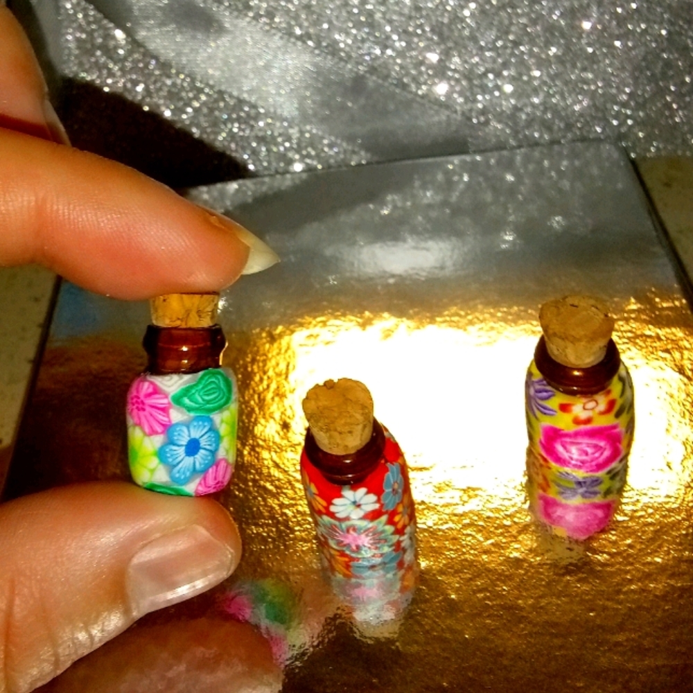 Miniature glass jars with clay wrap.